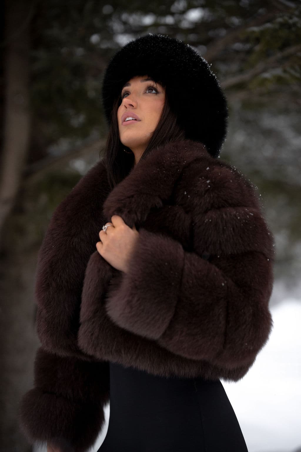 A sable fox jacket and a black fur hat, worn beneath snowy pines.